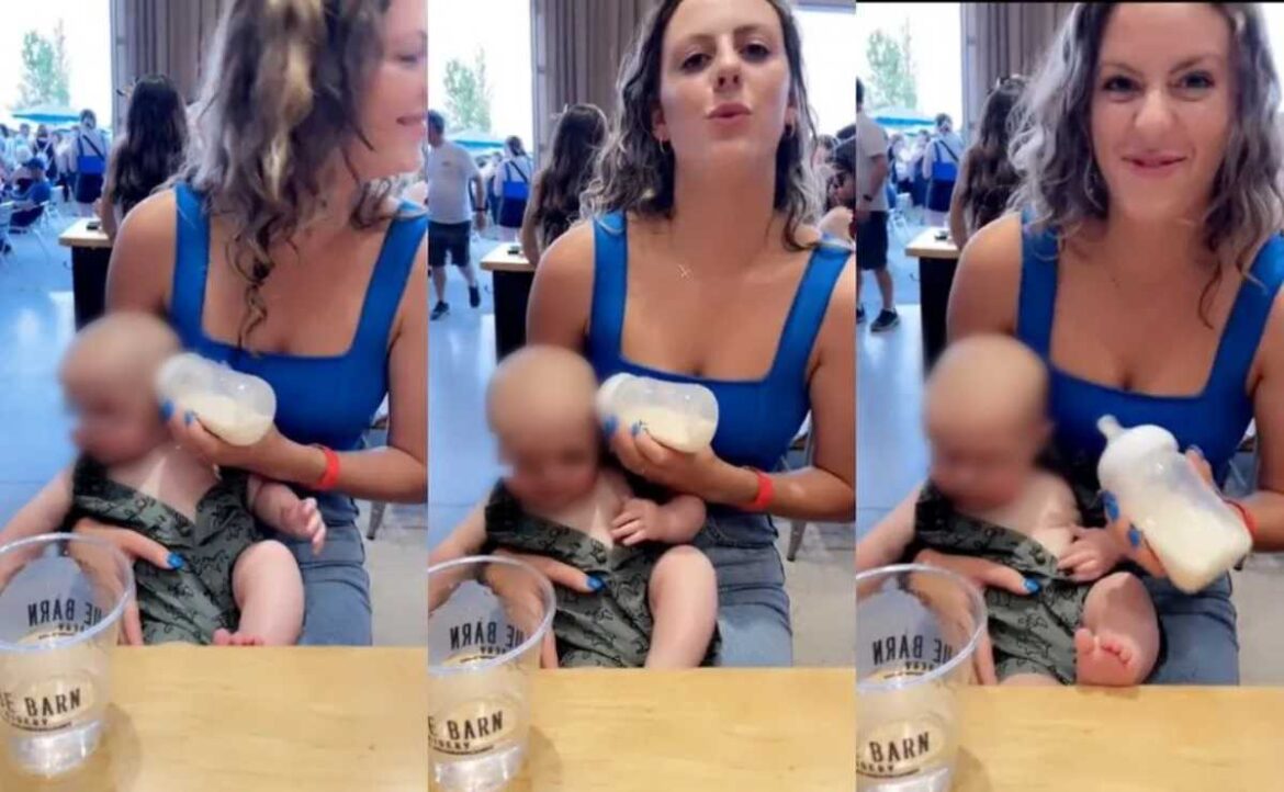 Distraída mamá da biberón en la oreja del bebé